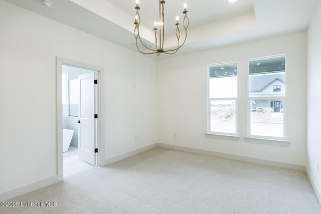 7450 55th St, Lubbock, TX 79407 - spare room featuring a chandelier, carpet, a tray ceiling, and baseboards