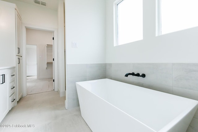 7450 55th St, Lubbock, TX 79407 - full bath featuring a freestanding tub, tile walls, and wainscoting