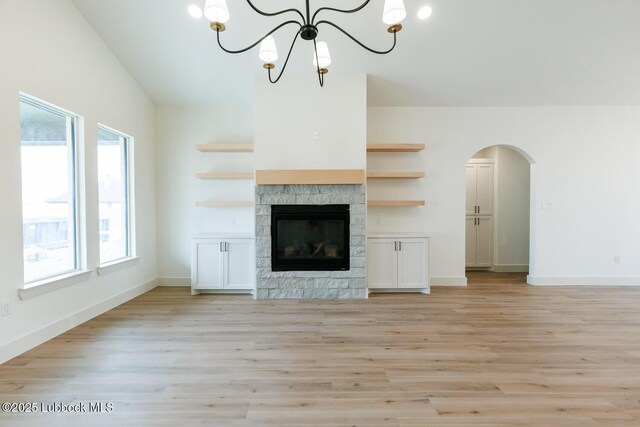 7450 55th St, Lubbock, TX 79407 - unfurnished living room with a chandelier, light wood-type flooring, a fireplace, and baseboards