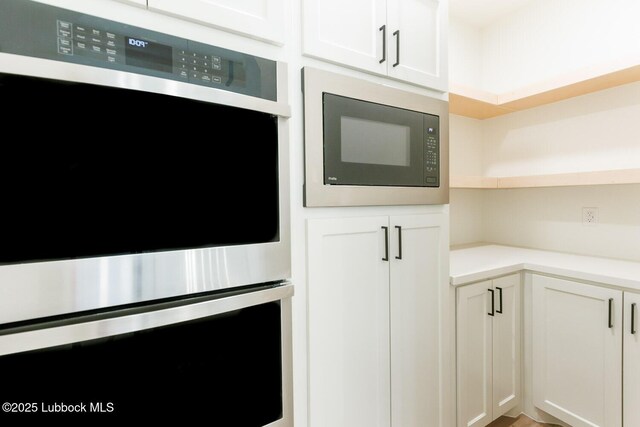 7450 55th St, Lubbock, TX 79407 - kitchen featuring appliances with stainless steel finishes, light countertops, open shelves, and white cabinets