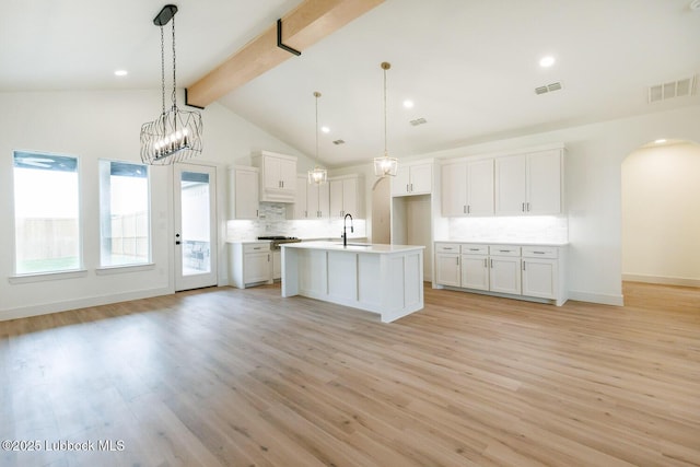 7450 55th St, Lubbock, TX 79407 - kitchen featuring backsplash, beam ceiling, white cabinetry, open floor plan, and light countertops