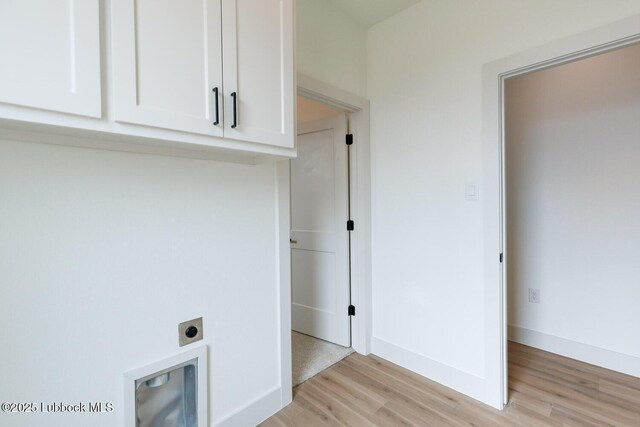 7450 55th St, Lubbock, TX 79407 - washroom with electric dryer hookup, cabinet space, light wood-style flooring, and baseboards