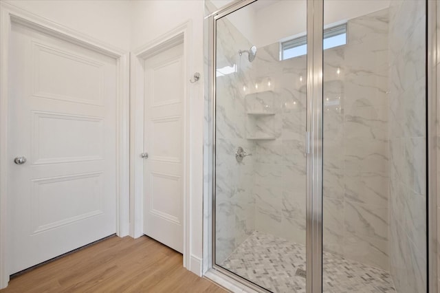 bathroom with hardwood / wood-style floors and a shower with door