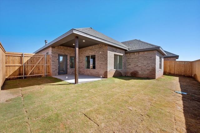 rear view of property featuring a yard and a patio