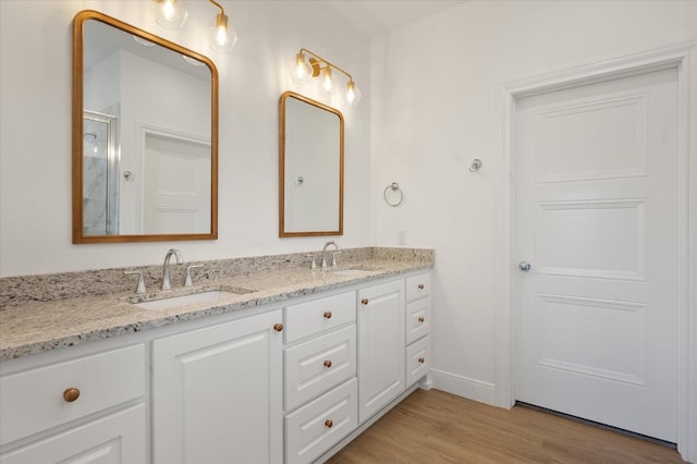 bathroom featuring hardwood / wood-style flooring, vanity, and a shower with shower door