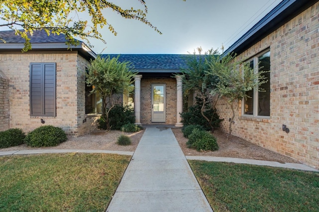 property entrance featuring a lawn