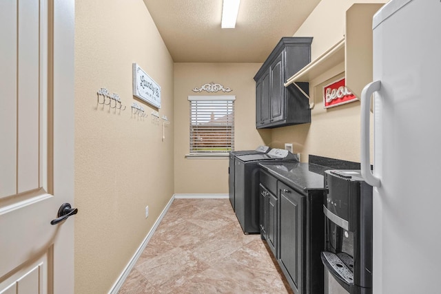 washroom with cabinets, washer and clothes dryer, and a textured ceiling