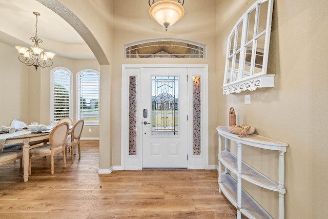 entrance foyer with hardwood / wood-style floors and a notable chandelier