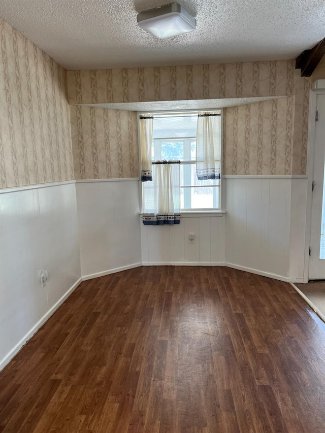 spare room with dark wood-type flooring and a textured ceiling