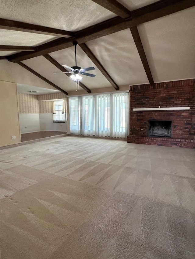 unfurnished living room featuring a wealth of natural light, vaulted ceiling with beams, and light colored carpet