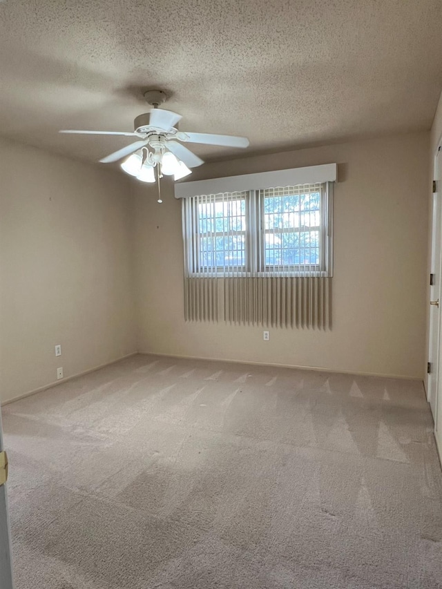 carpeted empty room featuring ceiling fan and a textured ceiling