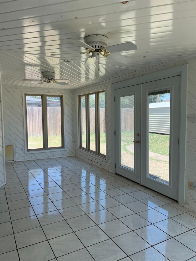 unfurnished sunroom featuring wooden ceiling, ceiling fan, and french doors