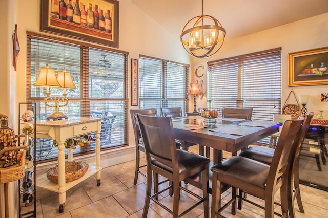 dining space with an inviting chandelier, vaulted ceiling, and light tile patterned floors