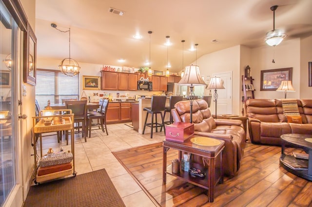 tiled living room featuring an inviting chandelier and lofted ceiling