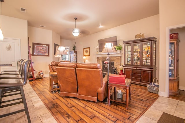 living room featuring a brick fireplace and light hardwood / wood-style flooring