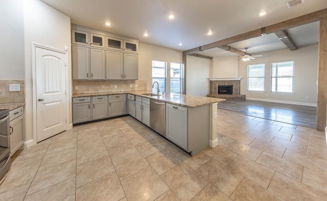 kitchen with appliances with stainless steel finishes, kitchen peninsula, sink, and backsplash