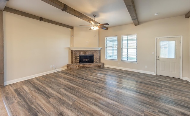 unfurnished living room with beamed ceiling, ceiling fan, dark wood-type flooring, and a fireplace