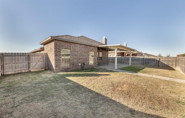 back of property featuring a patio and a yard