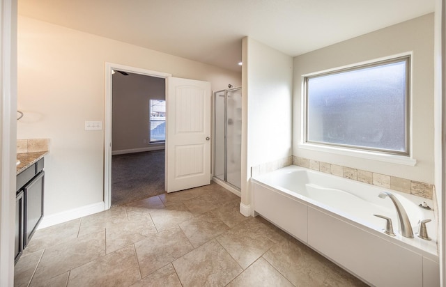 bathroom with independent shower and bath, vanity, and a healthy amount of sunlight