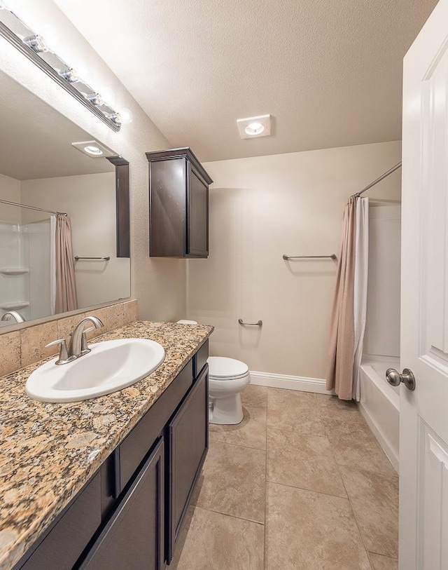 full bathroom featuring vanity, toilet, tile patterned floors, a textured ceiling, and shower / bath combo with shower curtain