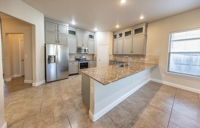 kitchen with tasteful backsplash, appliances with stainless steel finishes, sink, and kitchen peninsula