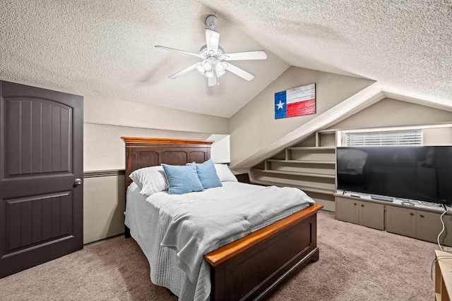 carpeted bedroom featuring ceiling fan, lofted ceiling, and a textured ceiling