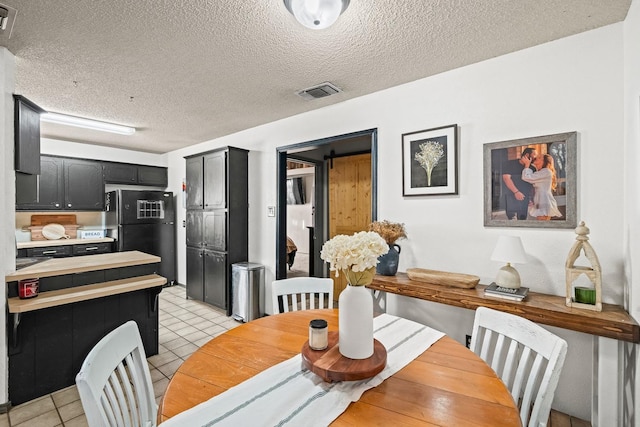 tiled dining room with a textured ceiling