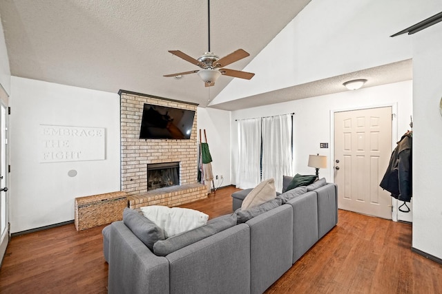 living room with hardwood / wood-style floors, a textured ceiling, a fireplace, and ceiling fan