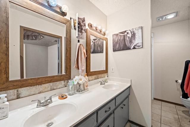 bathroom with tile patterned floors, vanity, toilet, and a textured ceiling