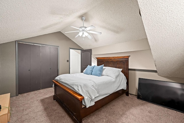 carpeted bedroom with ceiling fan, lofted ceiling, a closet, and a textured ceiling