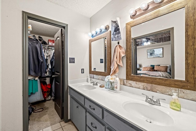 bathroom featuring tile patterned floors, vanity, and a textured ceiling