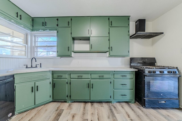 kitchen featuring sink, black appliances, green cabinetry, and wall chimney exhaust hood