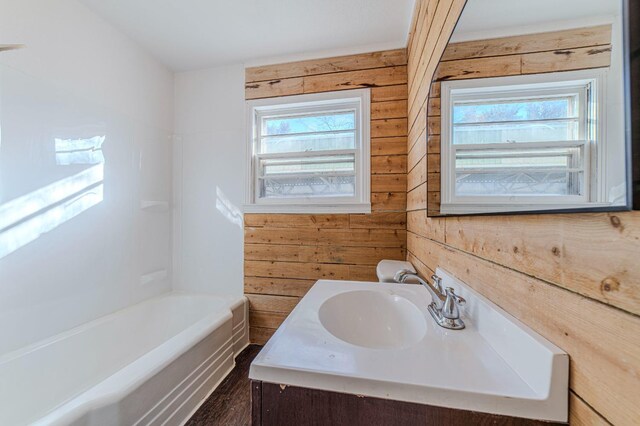 bathroom featuring vanity and wood walls