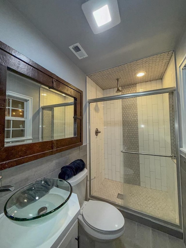 bathroom featuring vanity, toilet, and a shower with door