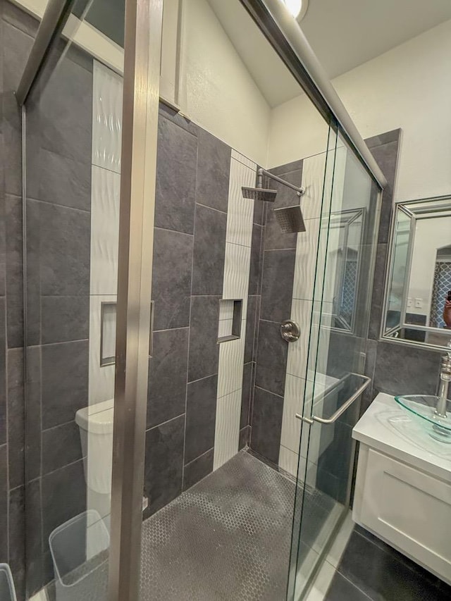 bathroom featuring vanity, tile patterned flooring, toilet, and walk in shower