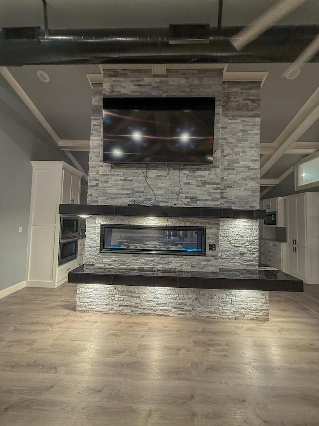 unfurnished living room with a stone fireplace and light hardwood / wood-style floors