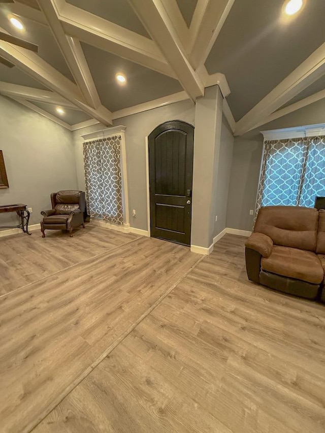 living area featuring lofted ceiling with beams and light wood-type flooring