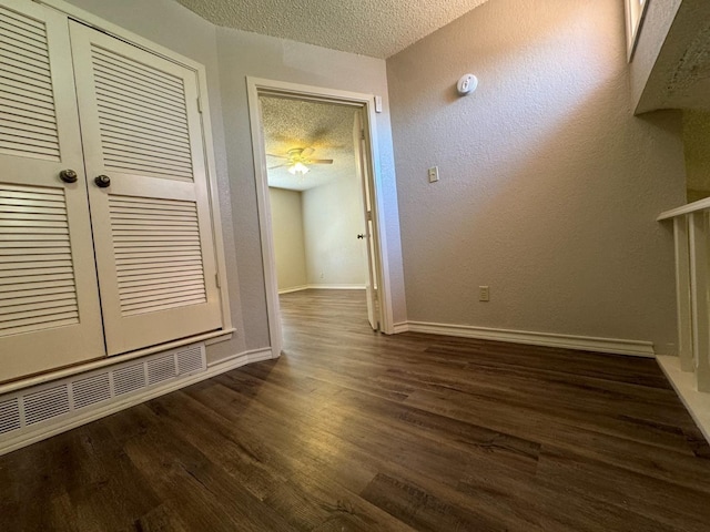 interior space with dark wood-type flooring and a textured ceiling