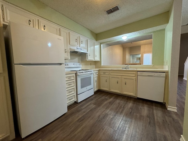 kitchen featuring sink, white appliances, white cabinetry, dark hardwood / wood-style floors, and a textured ceiling