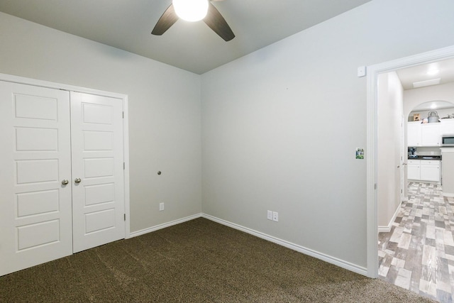 unfurnished bedroom featuring ceiling fan, carpet, and a closet