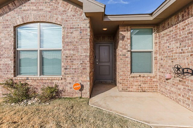 view of exterior entry with a patio area