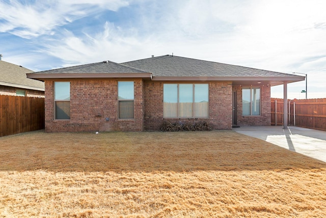 rear view of house featuring a lawn and a patio area