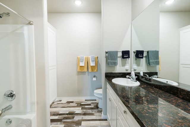 full bathroom featuring shower / bathing tub combination, hardwood / wood-style floors, vanity, and toilet