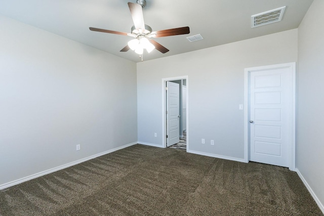 unfurnished room with ceiling fan and dark carpet