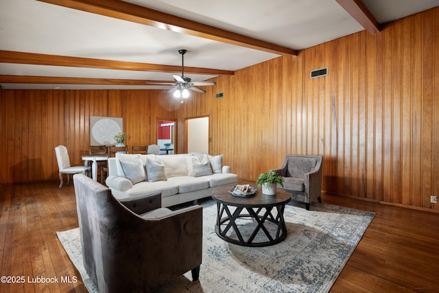 2005 32nd St, Lubbock, TX 79411 - living room with beam ceiling, hardwood / wood-style floors, a ceiling fan, and wood walls