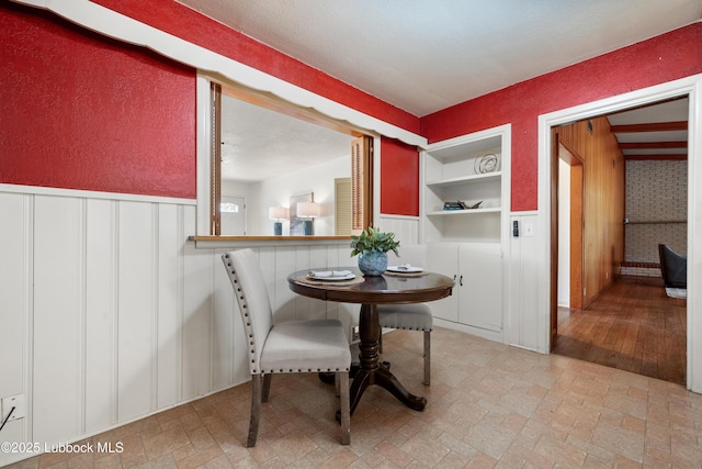 2005 32nd St, Lubbock, TX 79411 - dining area featuring built in shelves, wainscoting, and a decorative wall