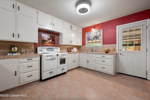 2005 32nd St, Lubbock, TX 79411 - kitchen featuring range with two ovens, light countertops, tasteful backsplash, and white cabinets