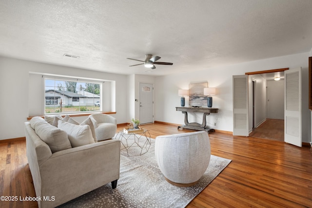2005 32nd St, Lubbock, TX 79411 - living area with a ceiling fan, wood finished floors, baseboards, and a textured ceiling