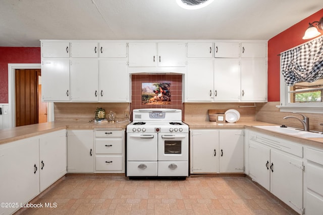 2005 32nd St, Lubbock, TX 79411 - kitchen with double oven range, backsplash, light countertops, and white cabinetry