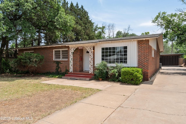 2005 32nd St, Lubbock, TX 79411 - view of front of house featuring brick siding, driveway, a front lawn, and a carport